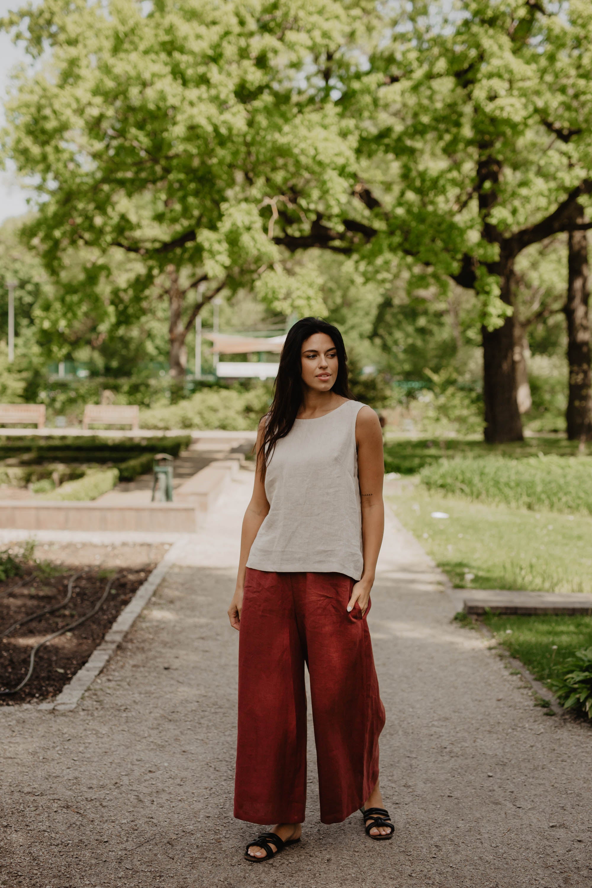 Woman In Park Wearing Wide Red Linen Pants and White Linen Top