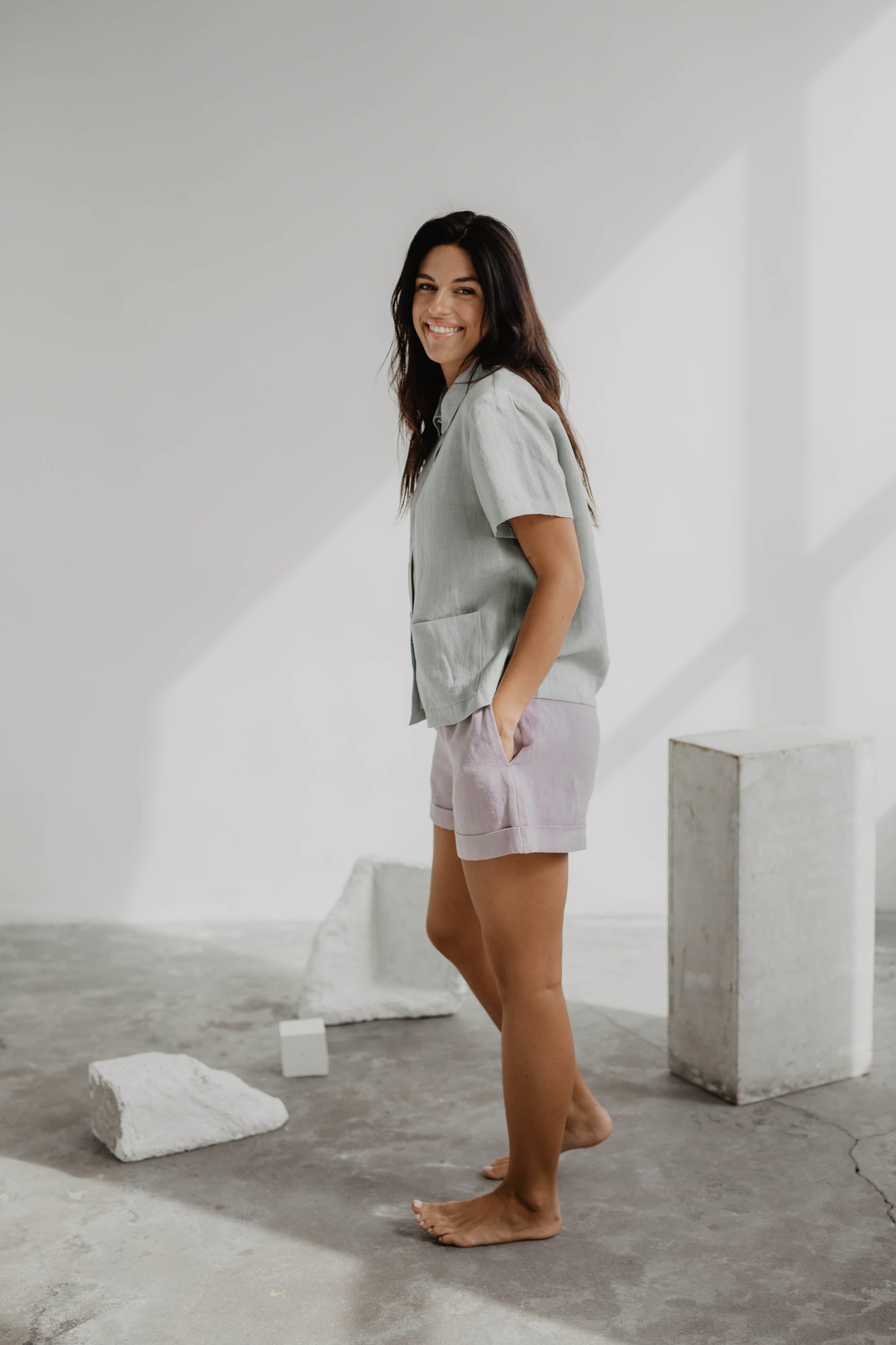 Side Of Woman Wearing Sage Green Linen Summer Shirt and Dusty Rose Linen Shorts