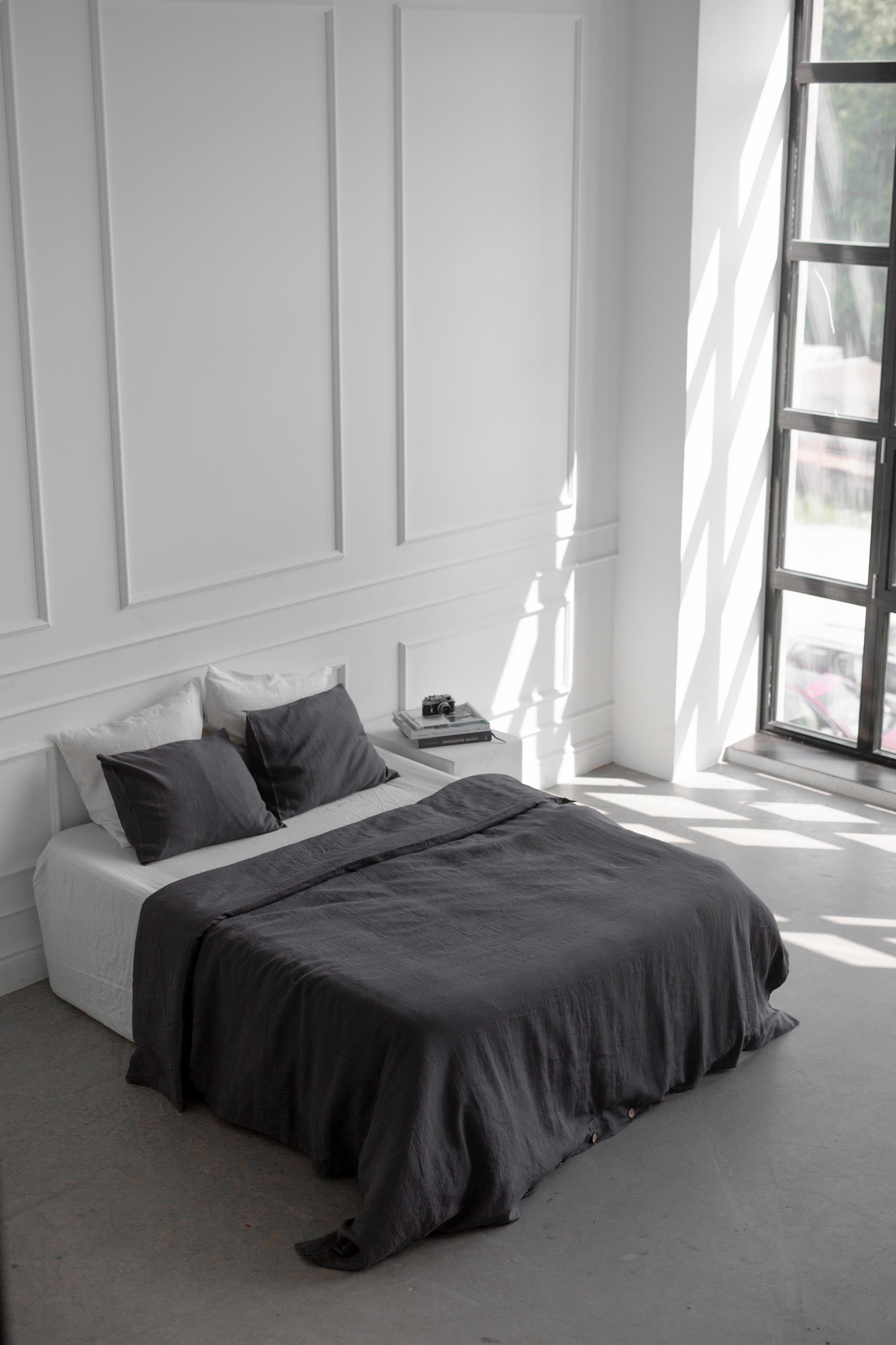 Bed With Charcoal Linen Bedding Set In A White Spacious Room