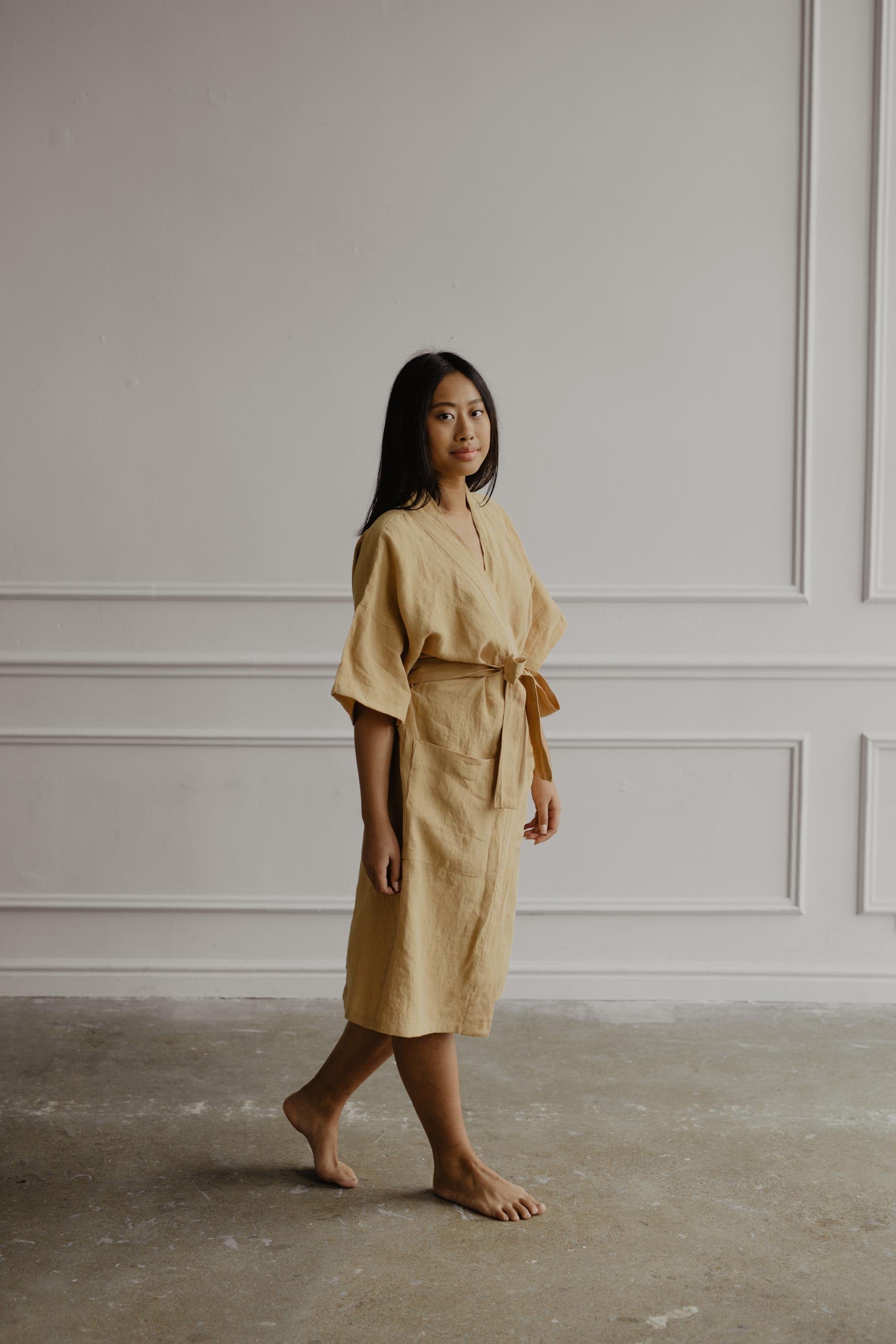 Woman Wearing A Mustard Linen Bathrobe in A White Room