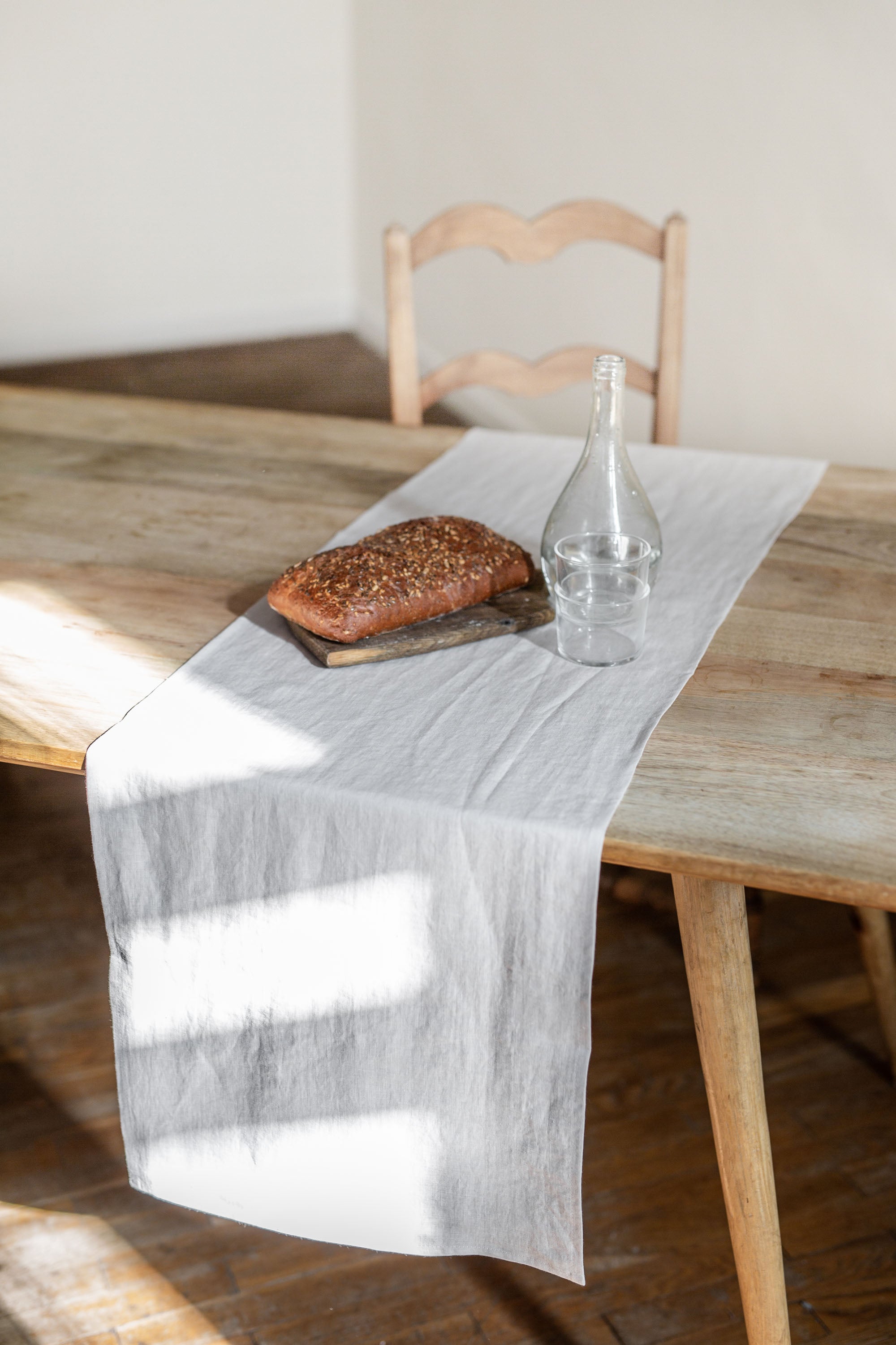 Load of Bread on Dinner Table With Cream Linen Table Runner By AmourlInen