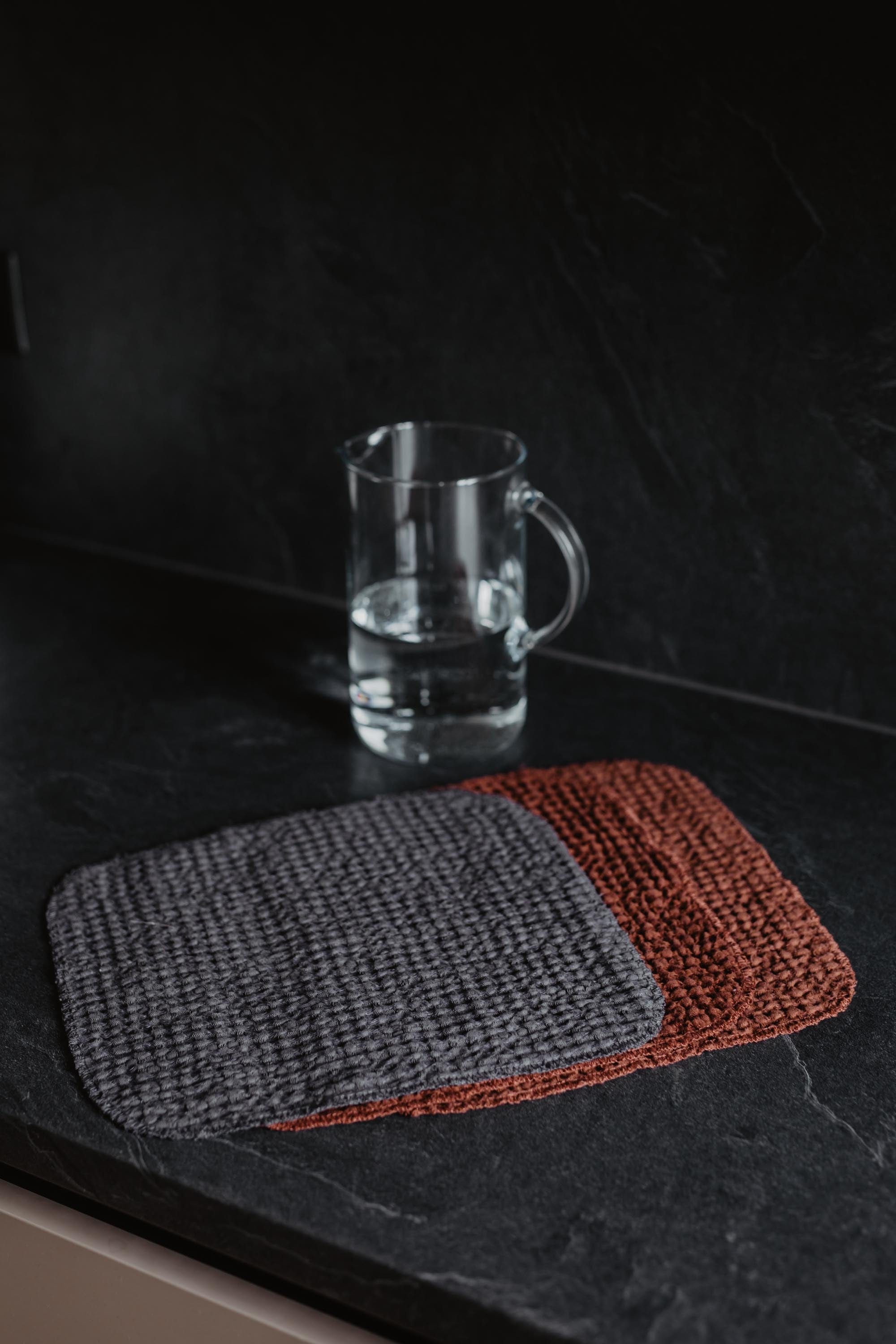 Three Dark Linen Waffle Wash Cloths On A Kitchen Counter