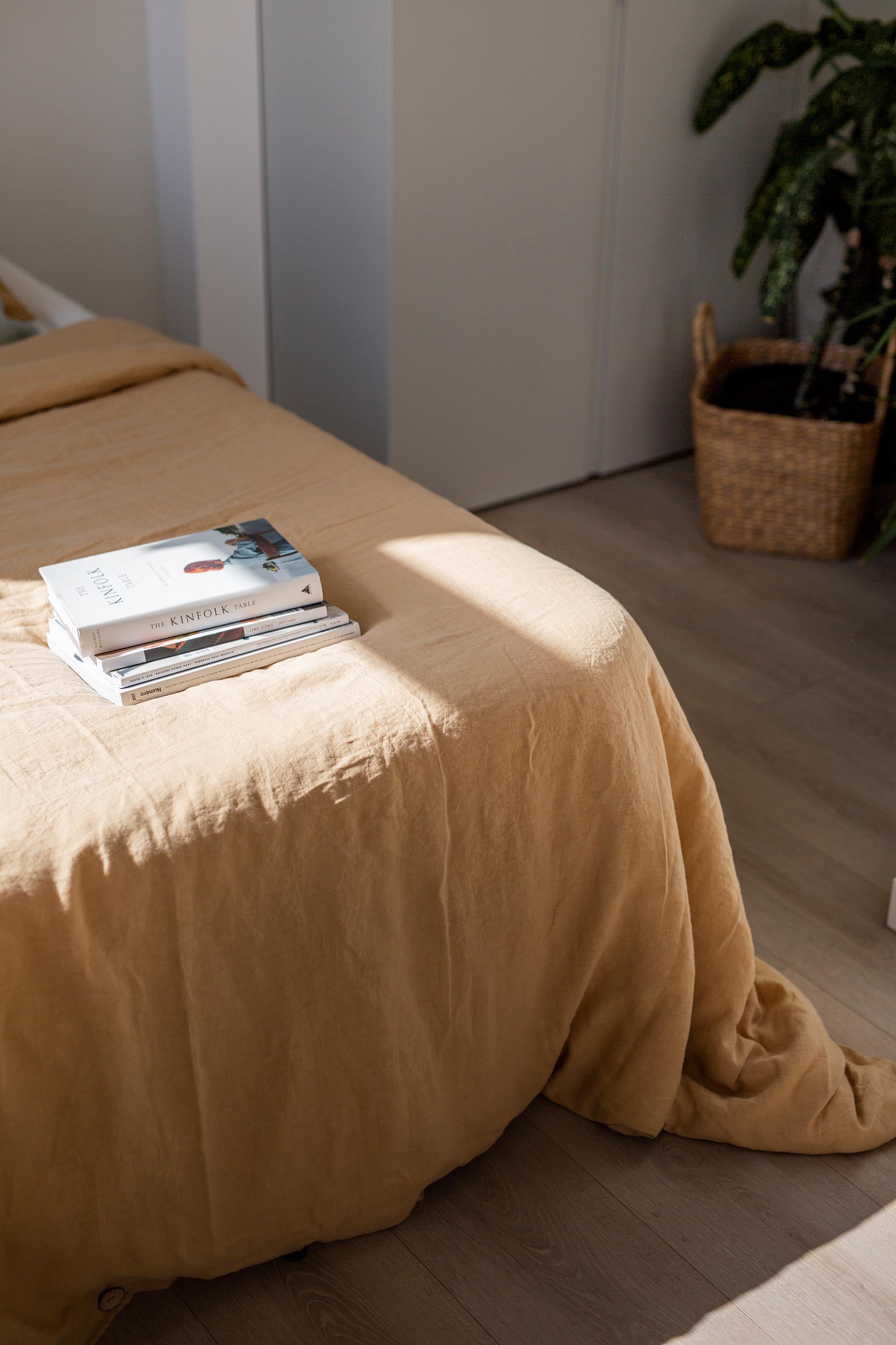 Corner of Bed With A Linen Duvet Cover In Mustard By AmourlInen
