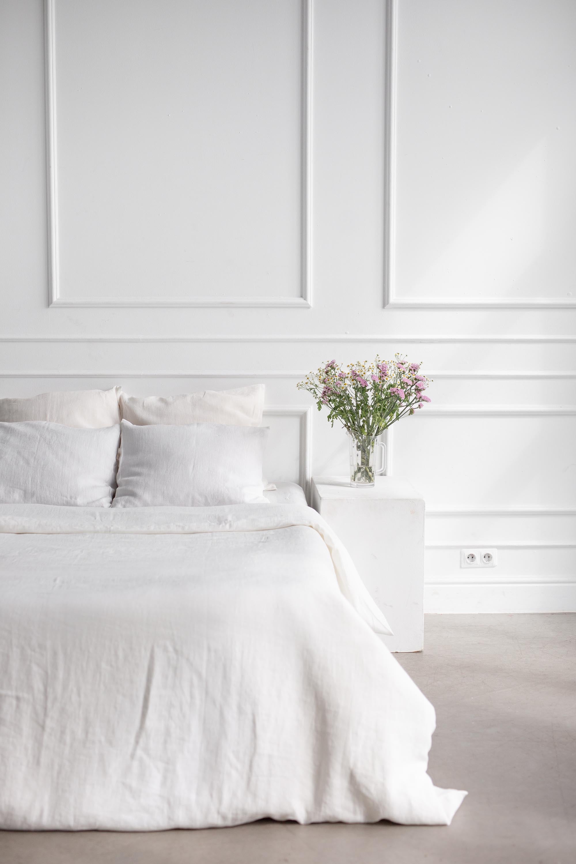 Corner of Bed With White Linen Duvet Cover By AmourlInen