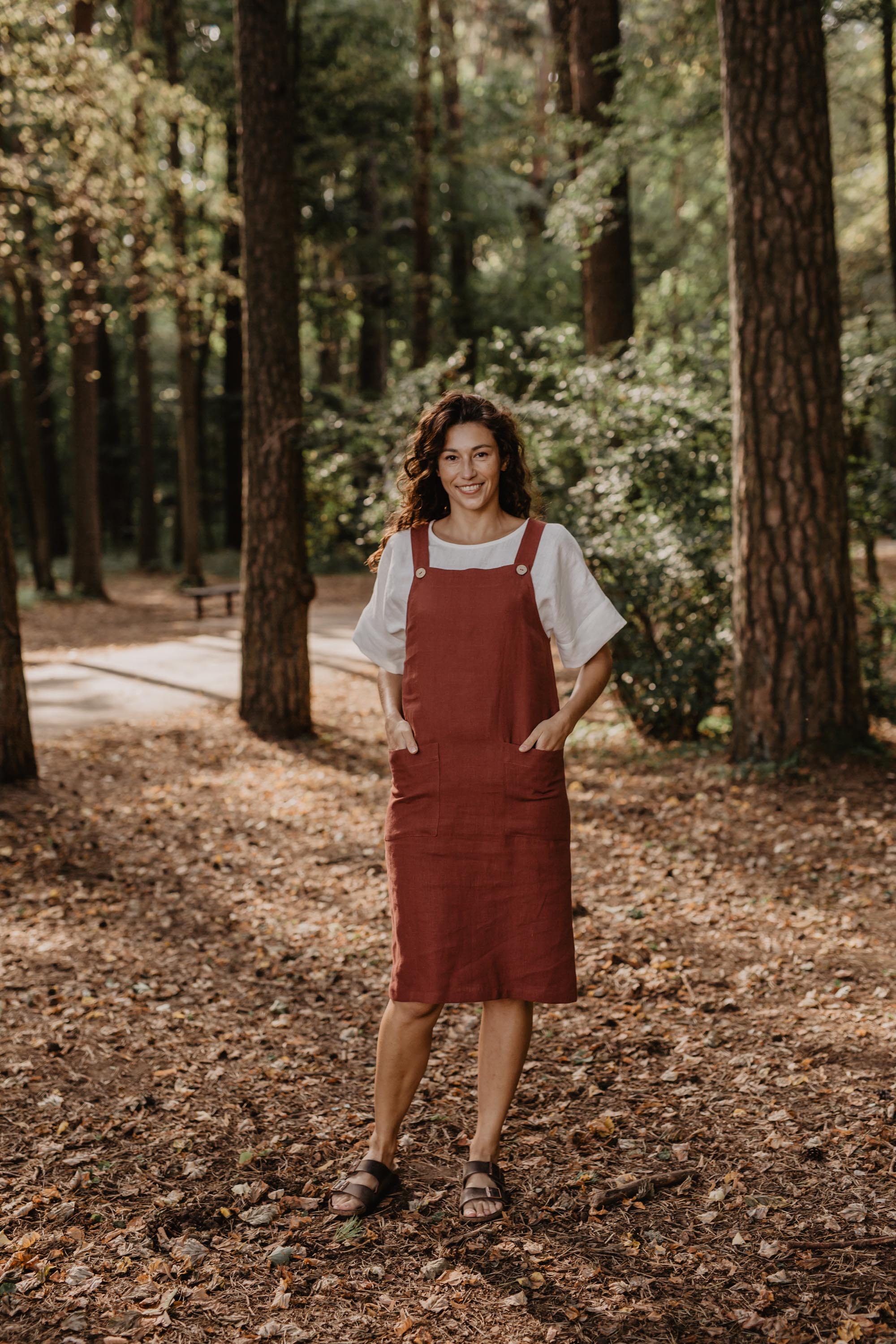 Front Of Women Wearing A Red Linen Apron Dress With White Top