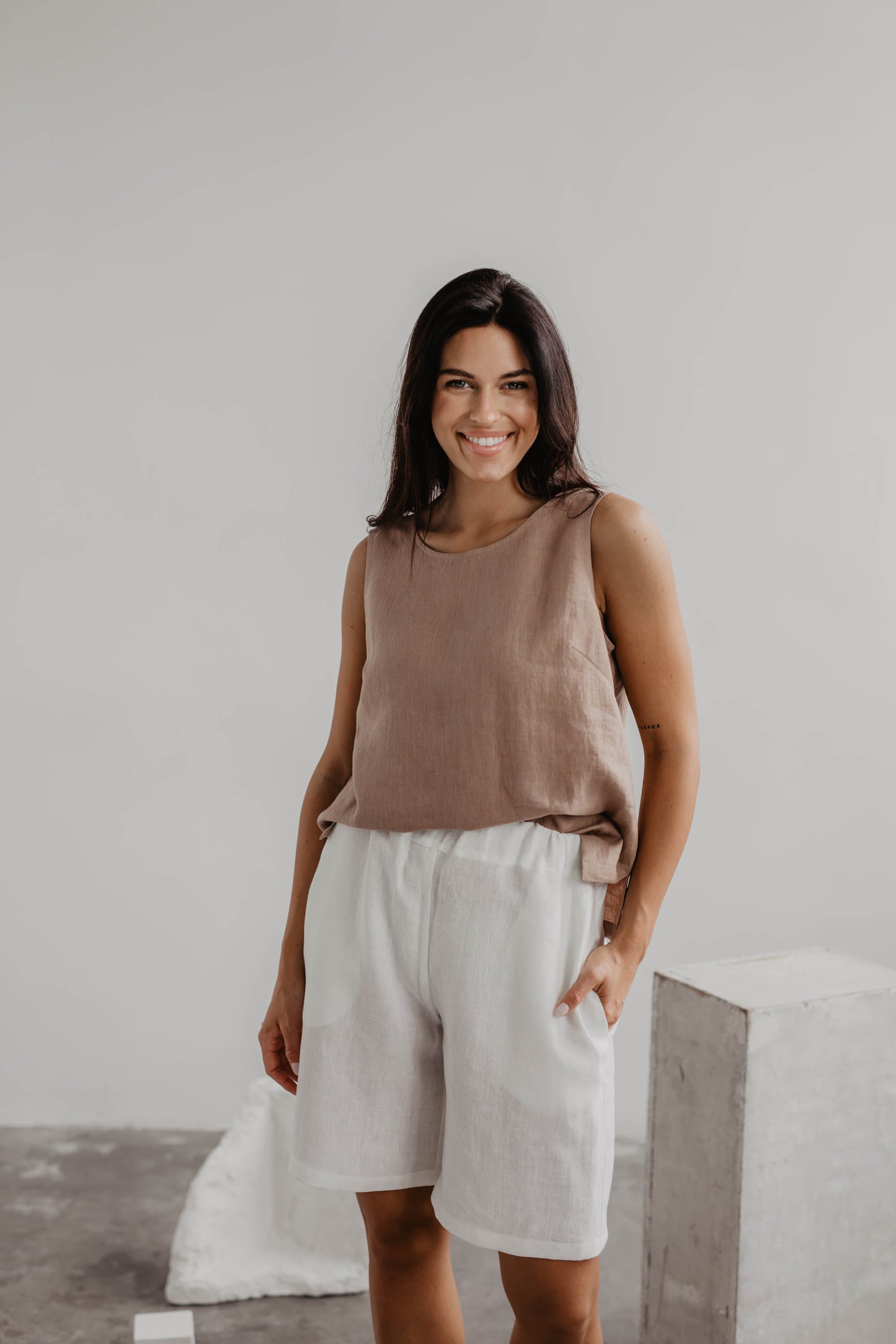 Woman Wearing A Dusty Rose Classical Linen Top With White Linen Shorts