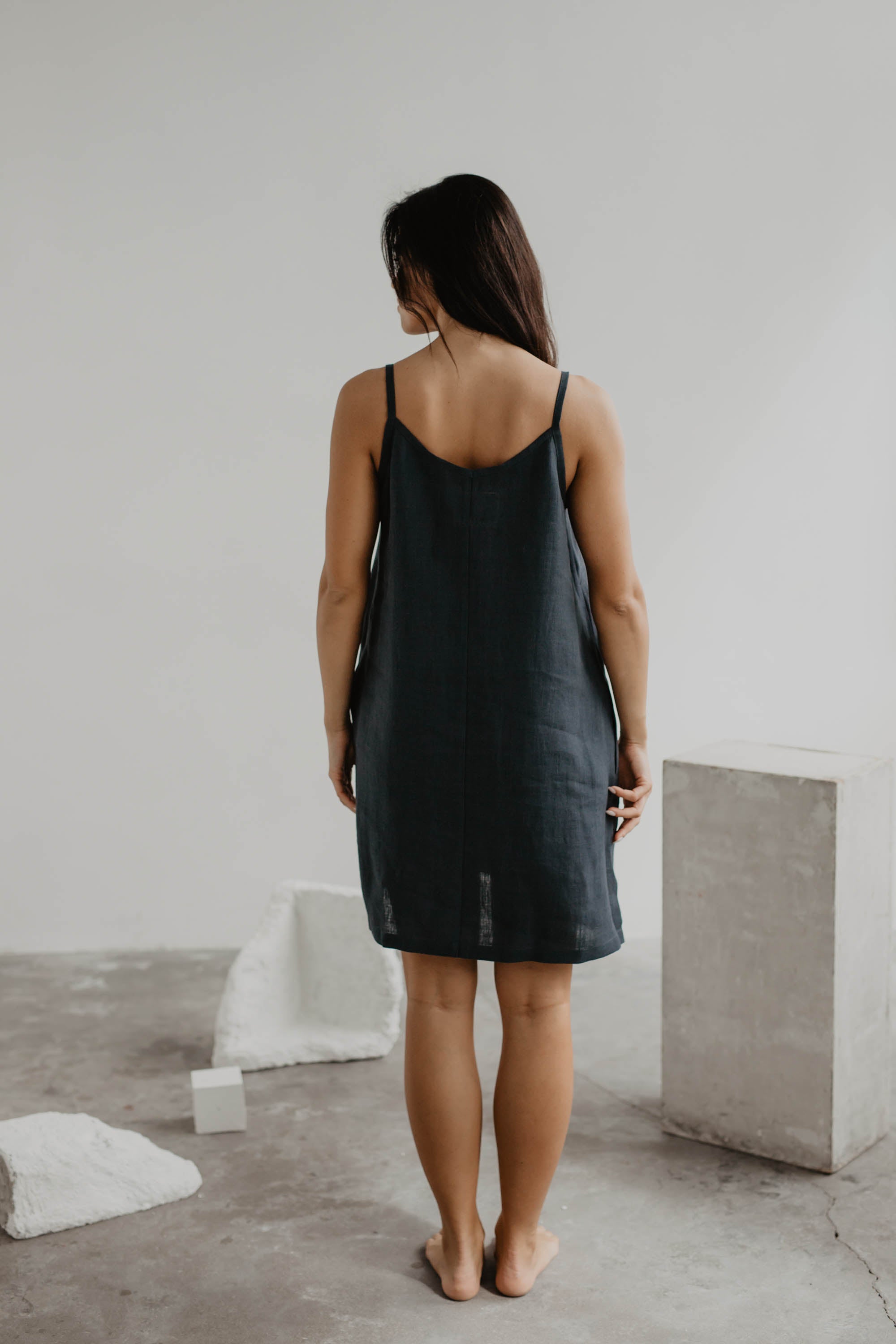 Back Of Women Wearing Black Slip Dress In Gallery by Amourlinen