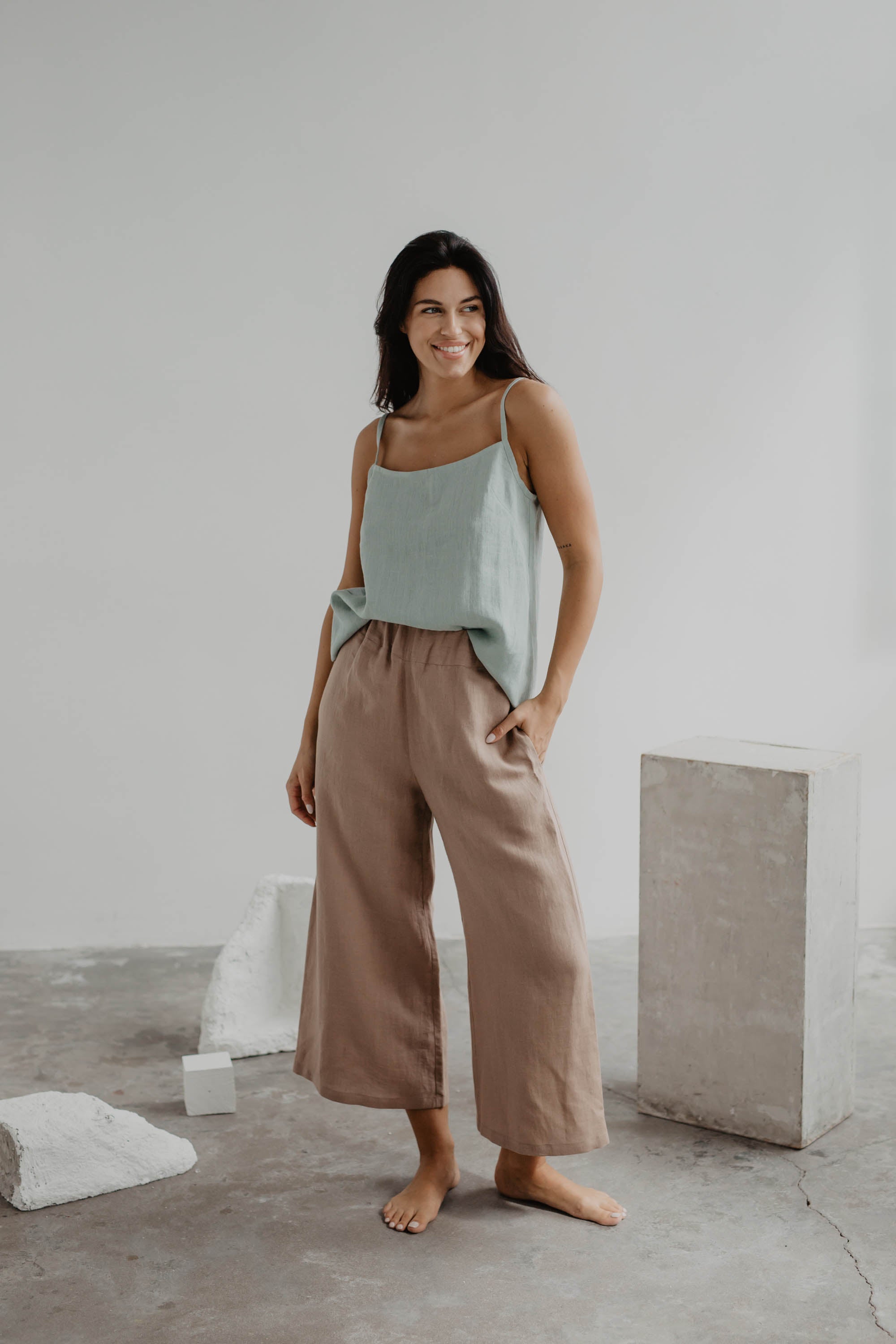 Woman In Gallery Wearing Dusty Rose Linen Pants and Sage Green Linen Top