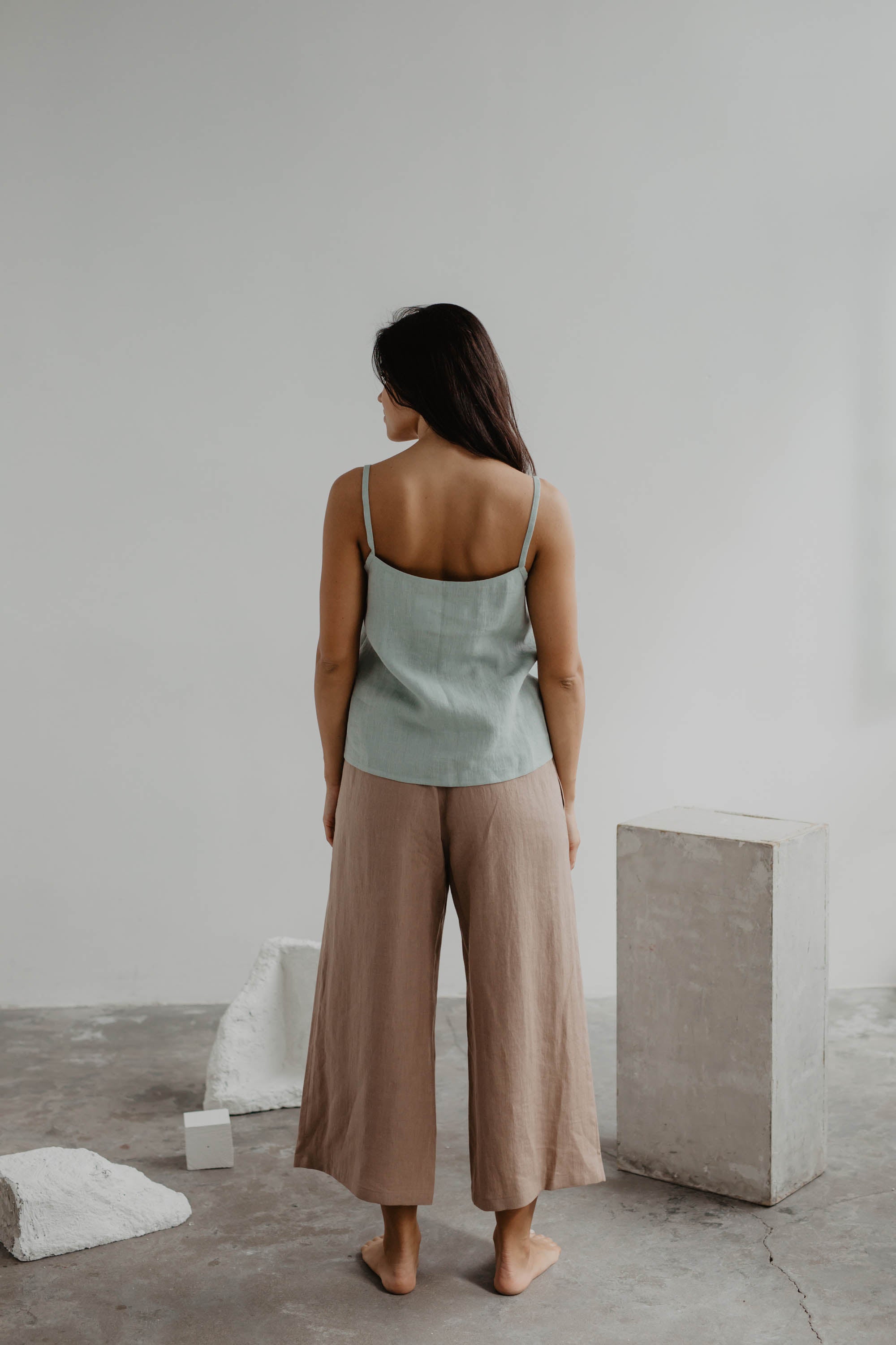Woman Facing Back Wearing A Sage Green Linen Top and Dusty Rose Linen Pants By Amourlinen
