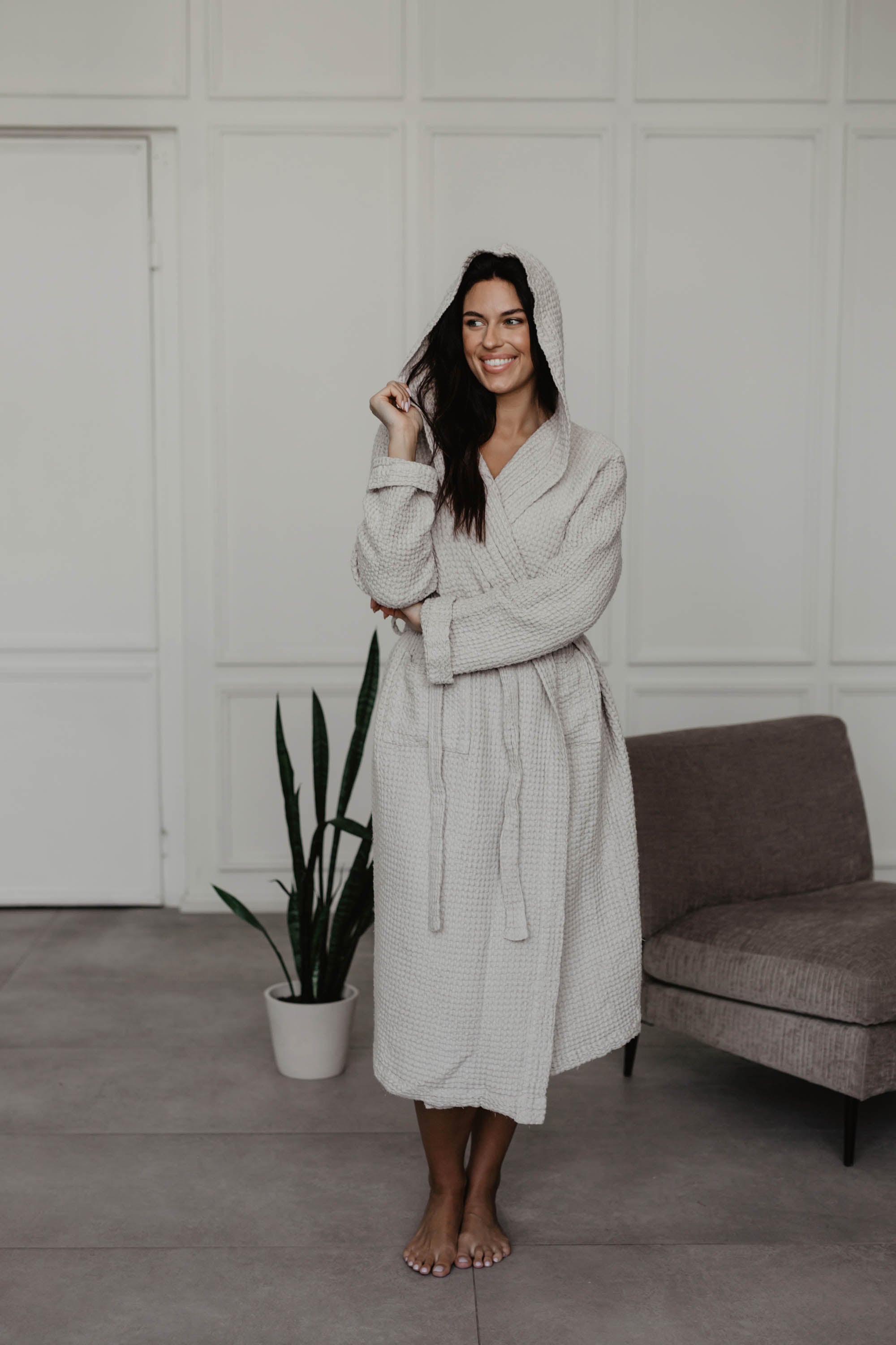 Woman Wearing A White Waffle Linen Bathrobe In A White Room