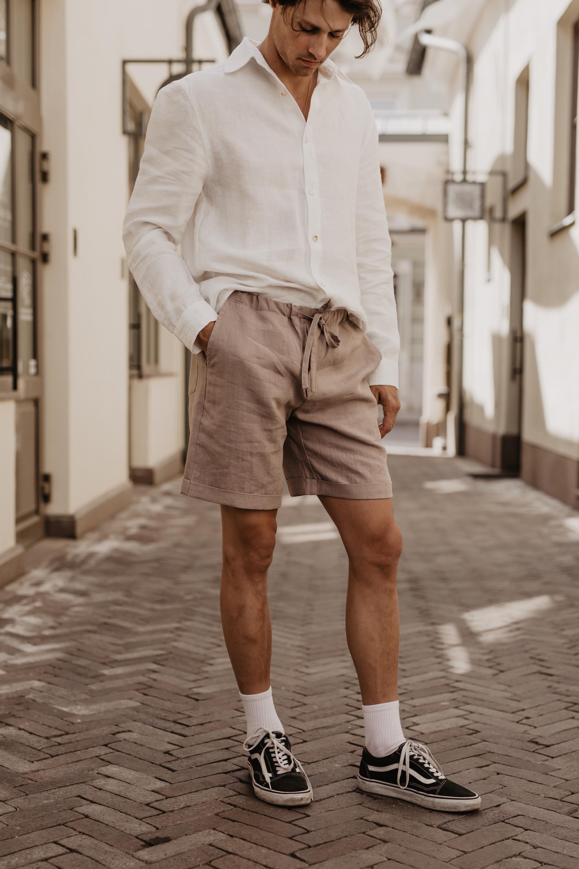 Man Wearing Dusty Rose Linen Shorts Looking Down