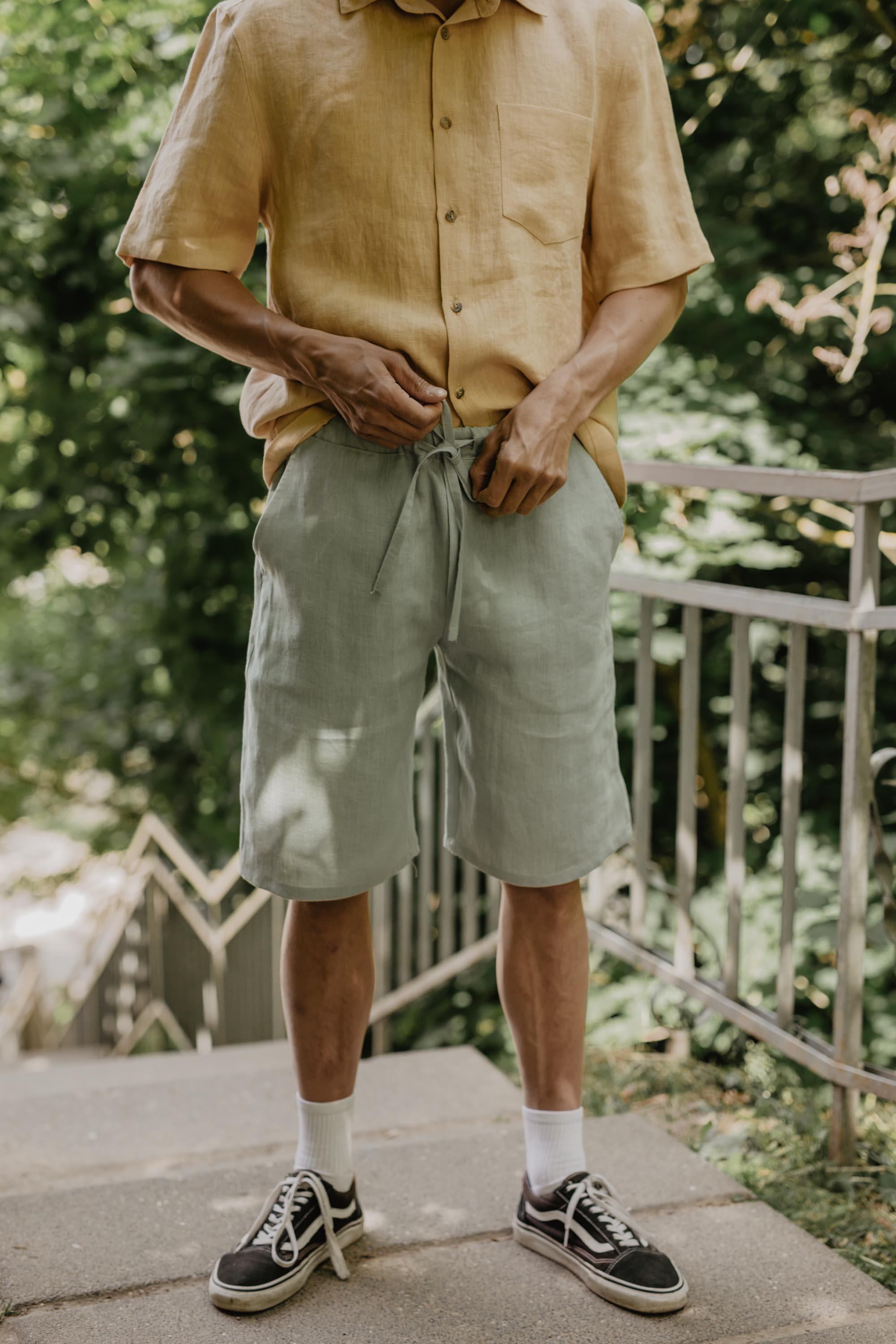 Man Adjusting Sage Green Linen Shorts