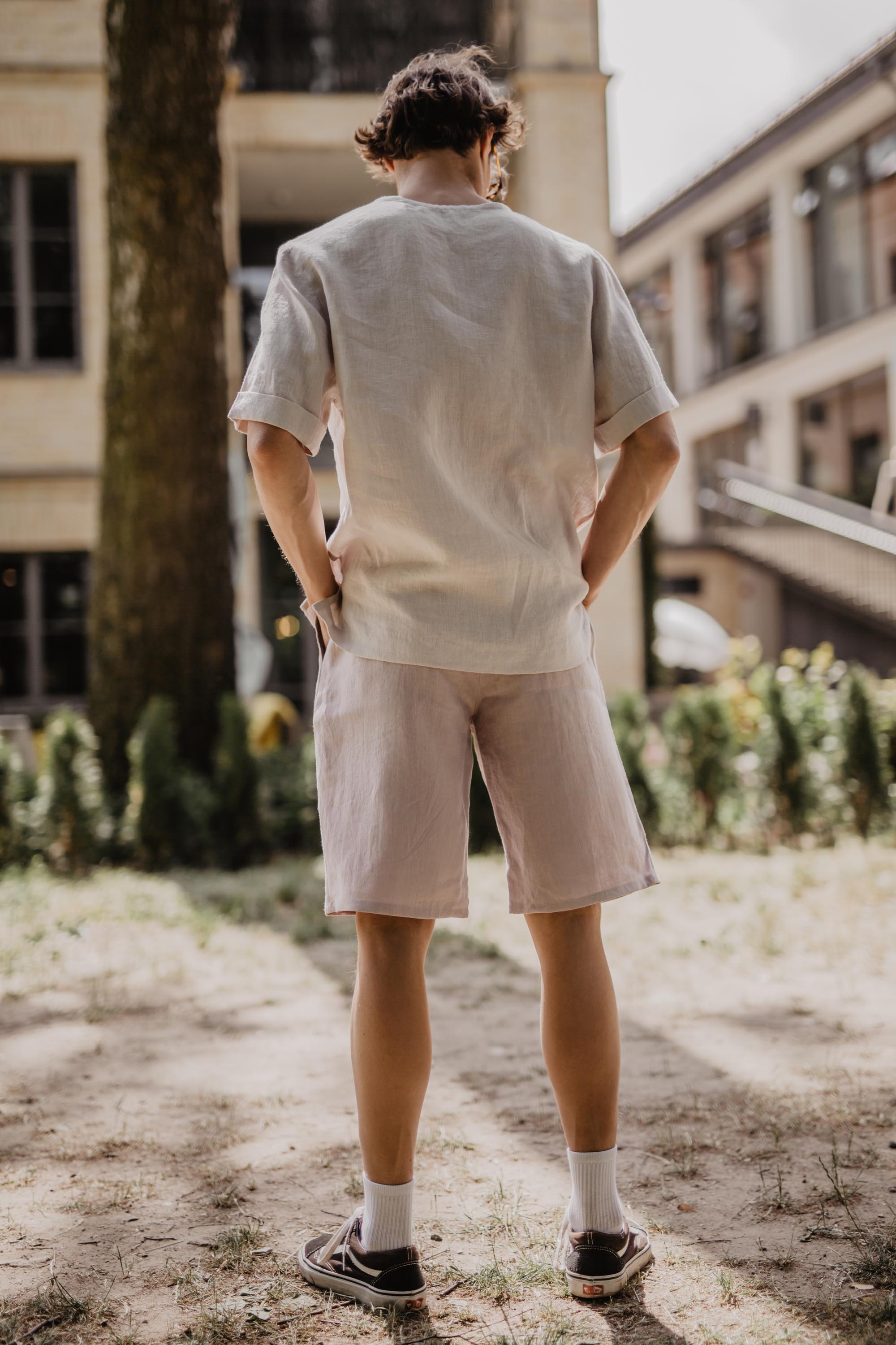 Man Facing Away Wearing White Linen T-Shirt And Cotton Candy Color Linen Shorts