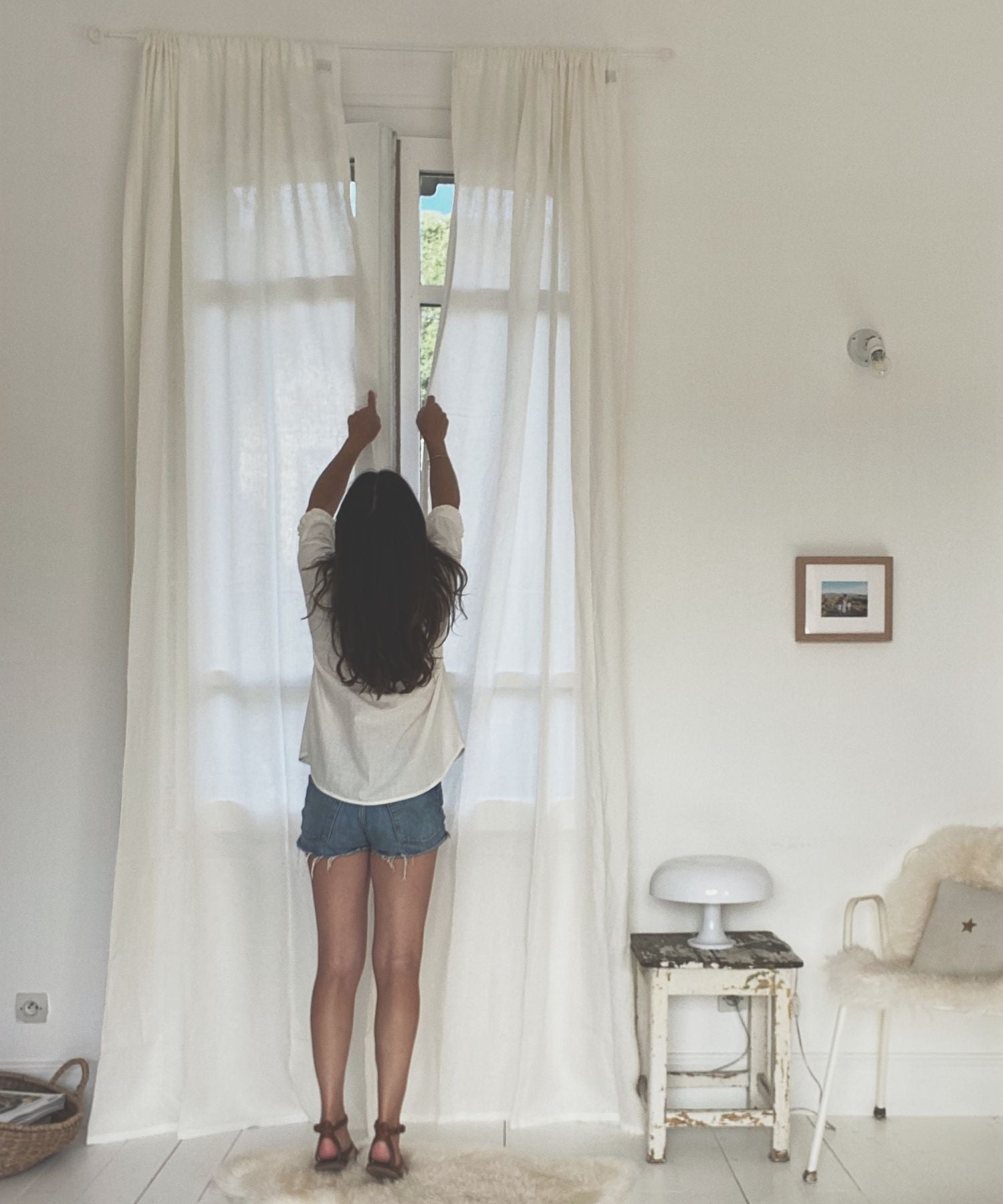 Women Adjusting White Linen Curtains
