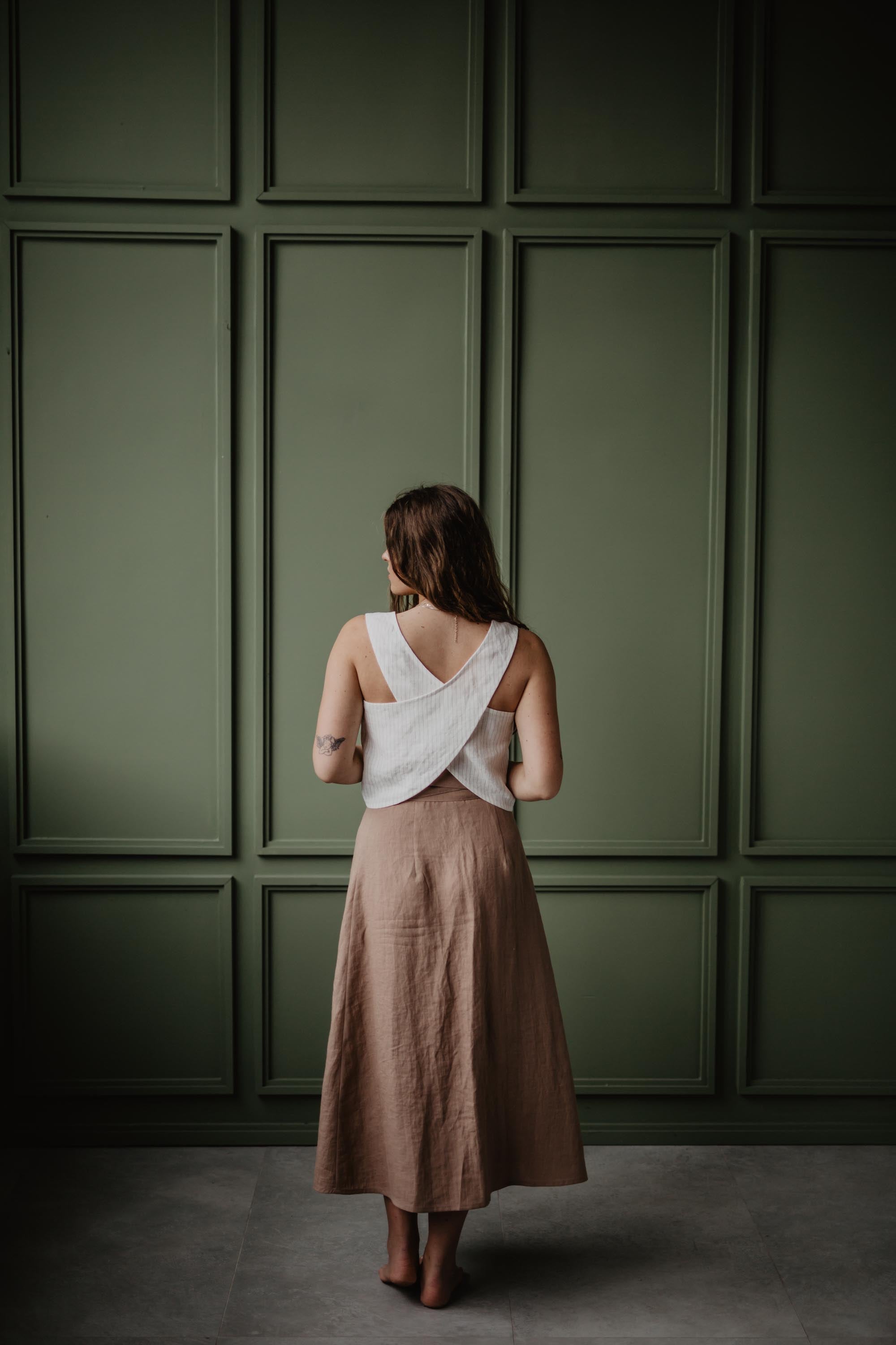 Back Of Woman Wearing A White Linen Pinafore Top with A Dusty Rose Linen Long Skirt