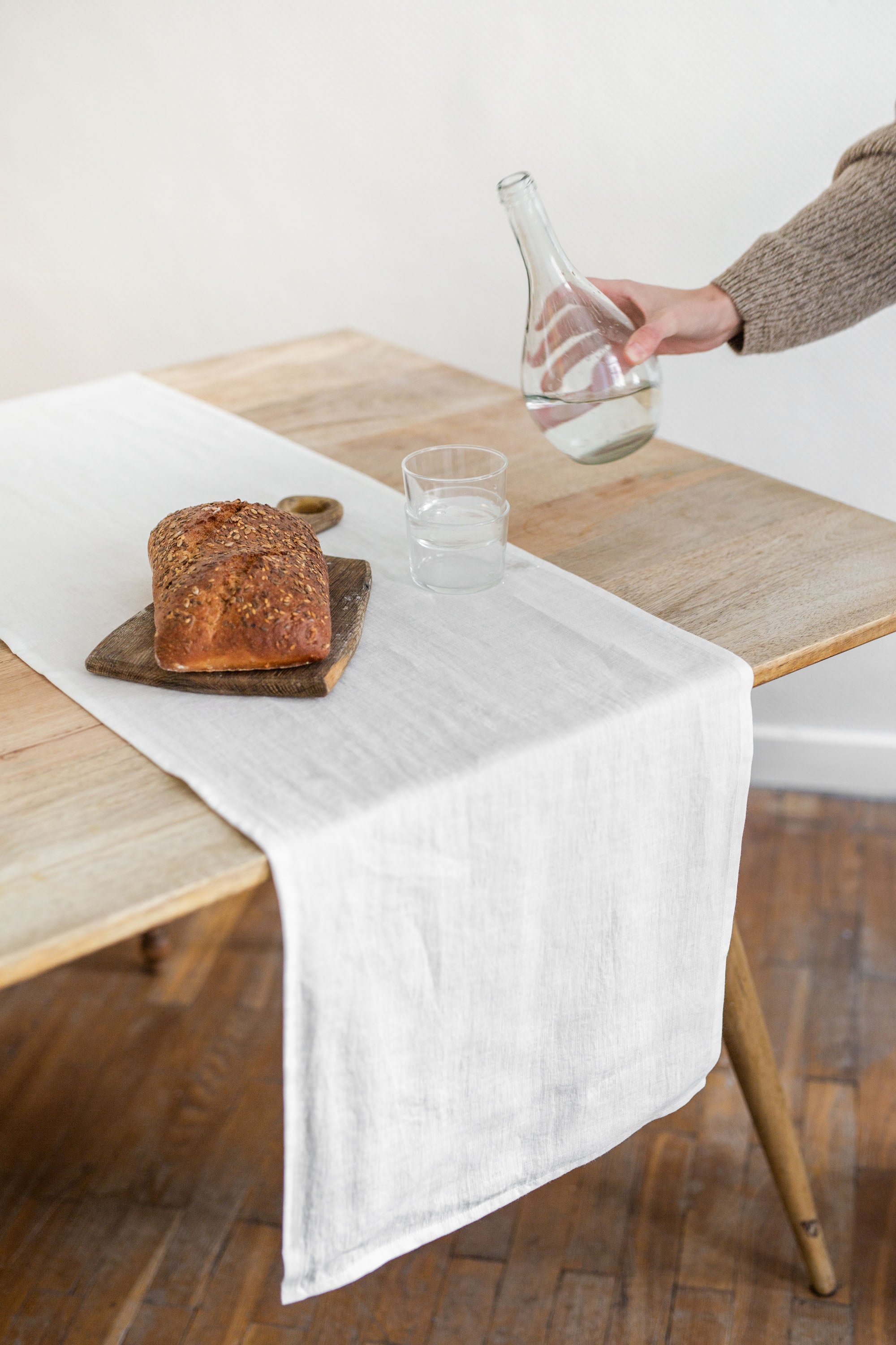 Load Of Bread On Rustic Dinner Table With White Linen Table Runner By AmourlInen