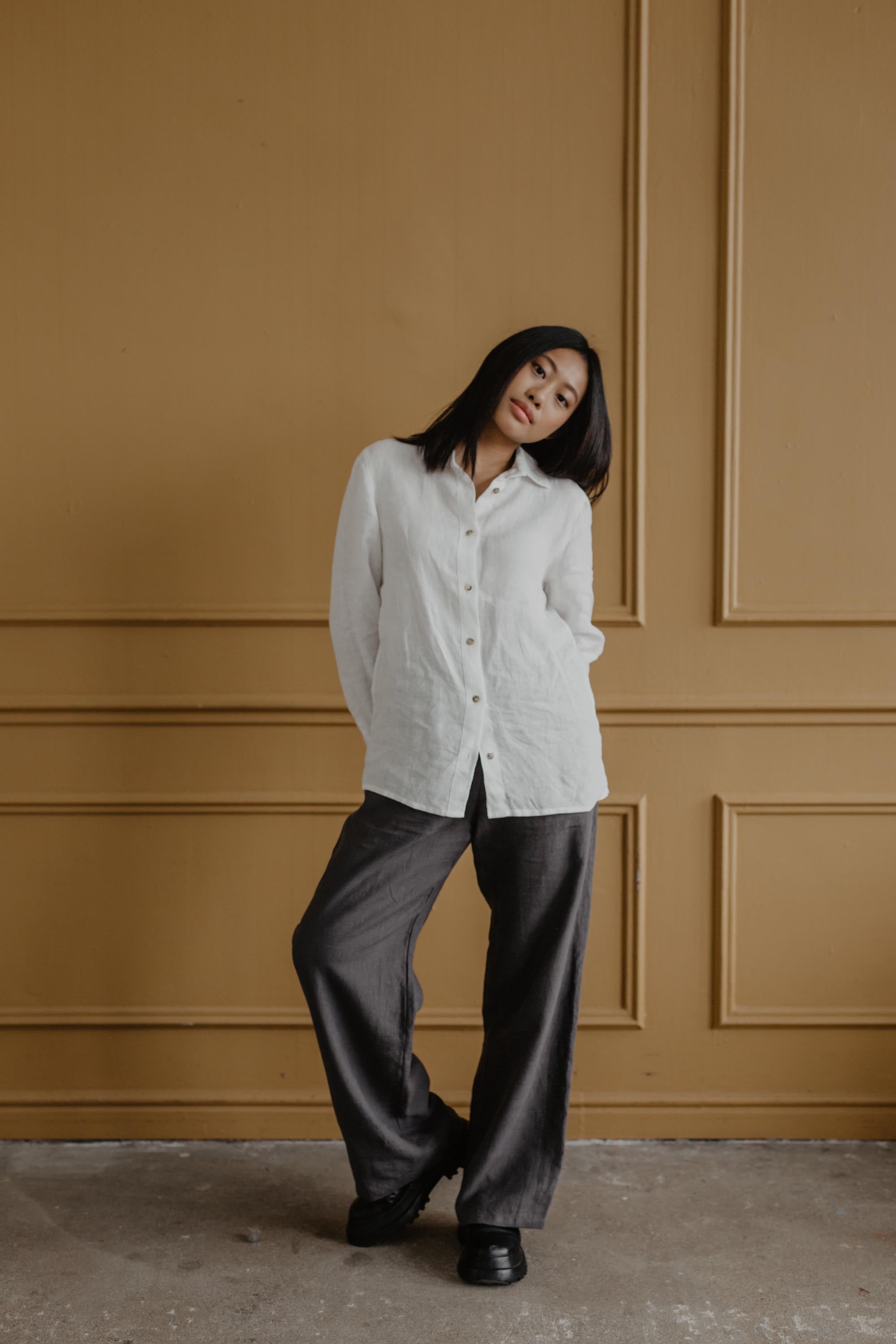 Woman Posing Wearing A White Classic Linen Shirt and Grey Linen Pants By AmourLinen