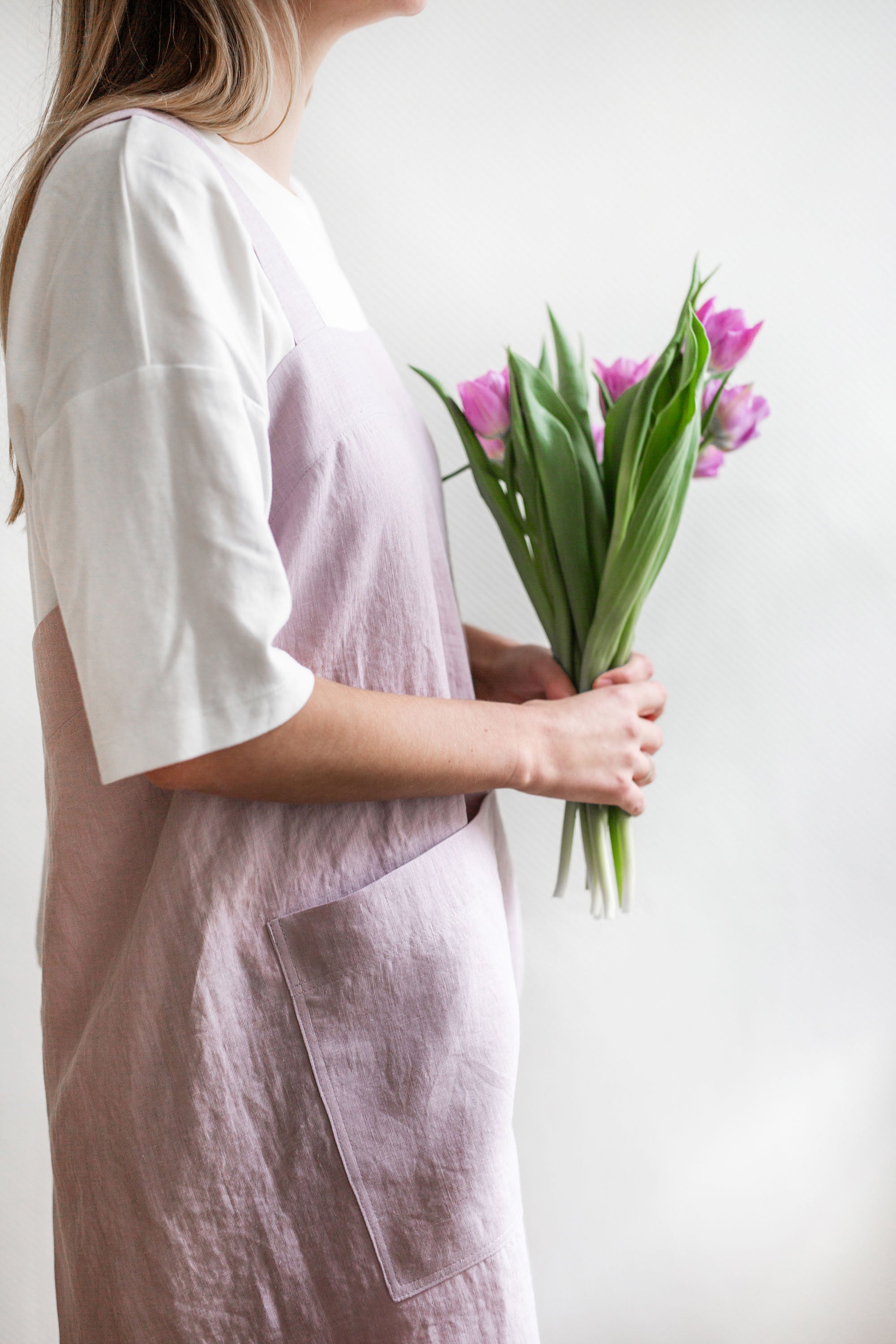 Woman Holding a Flowers Wearing Pinafore Linen Apron In Cotton Candy By AmourlInen