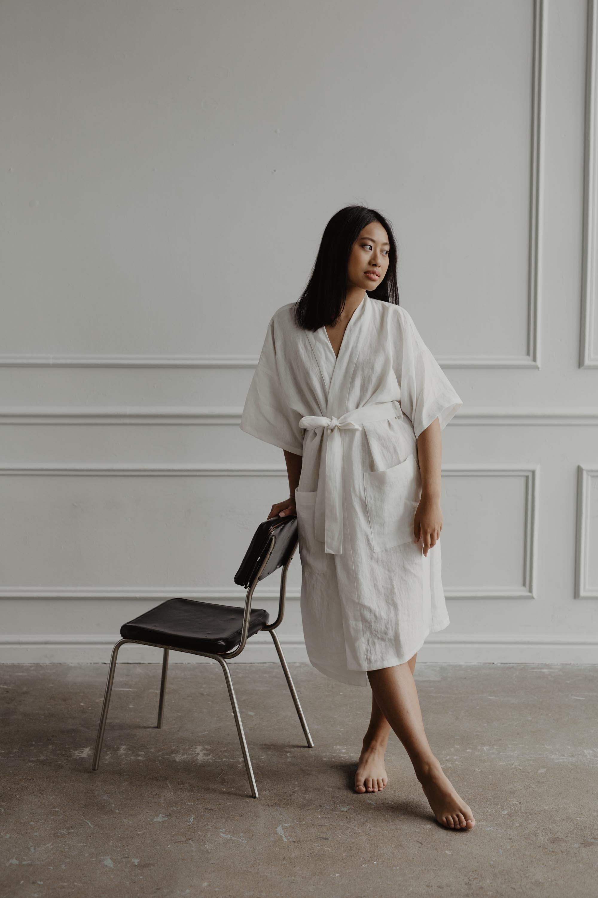 Woman Leaning On Chair Wearing A White Linen Bathrobe By AmourLinen