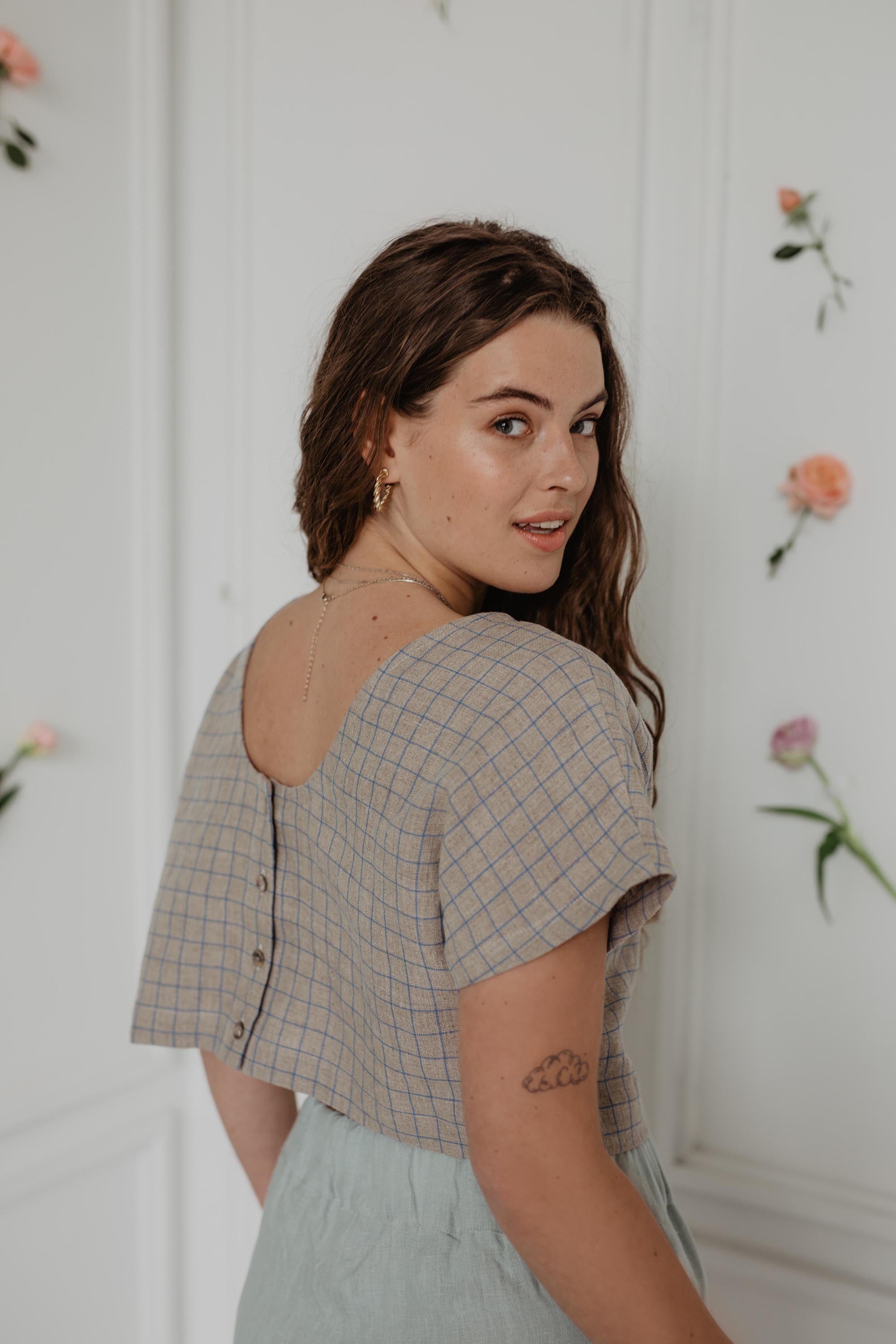 Close Up Of Woman Turning To Side Wearing A Checkered Linen Crop Top  With Buttons