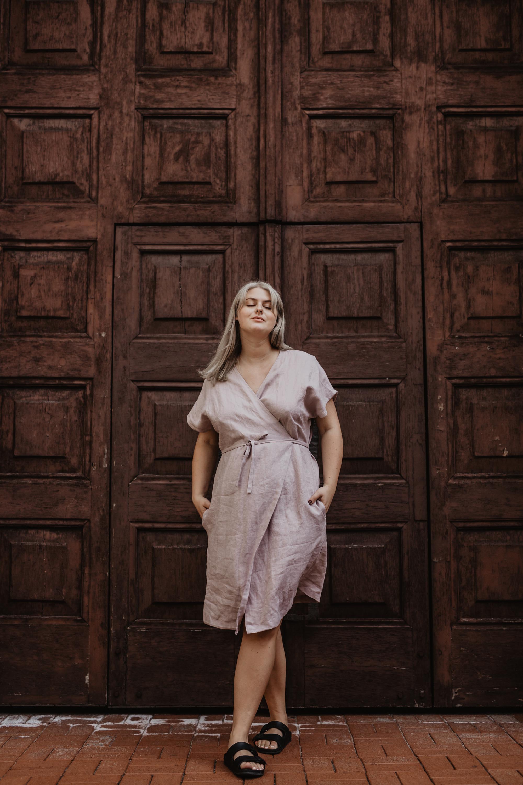 Woman Next To Door Wearing A Dusty Rose Linen Wrap Dress By AmourLinen