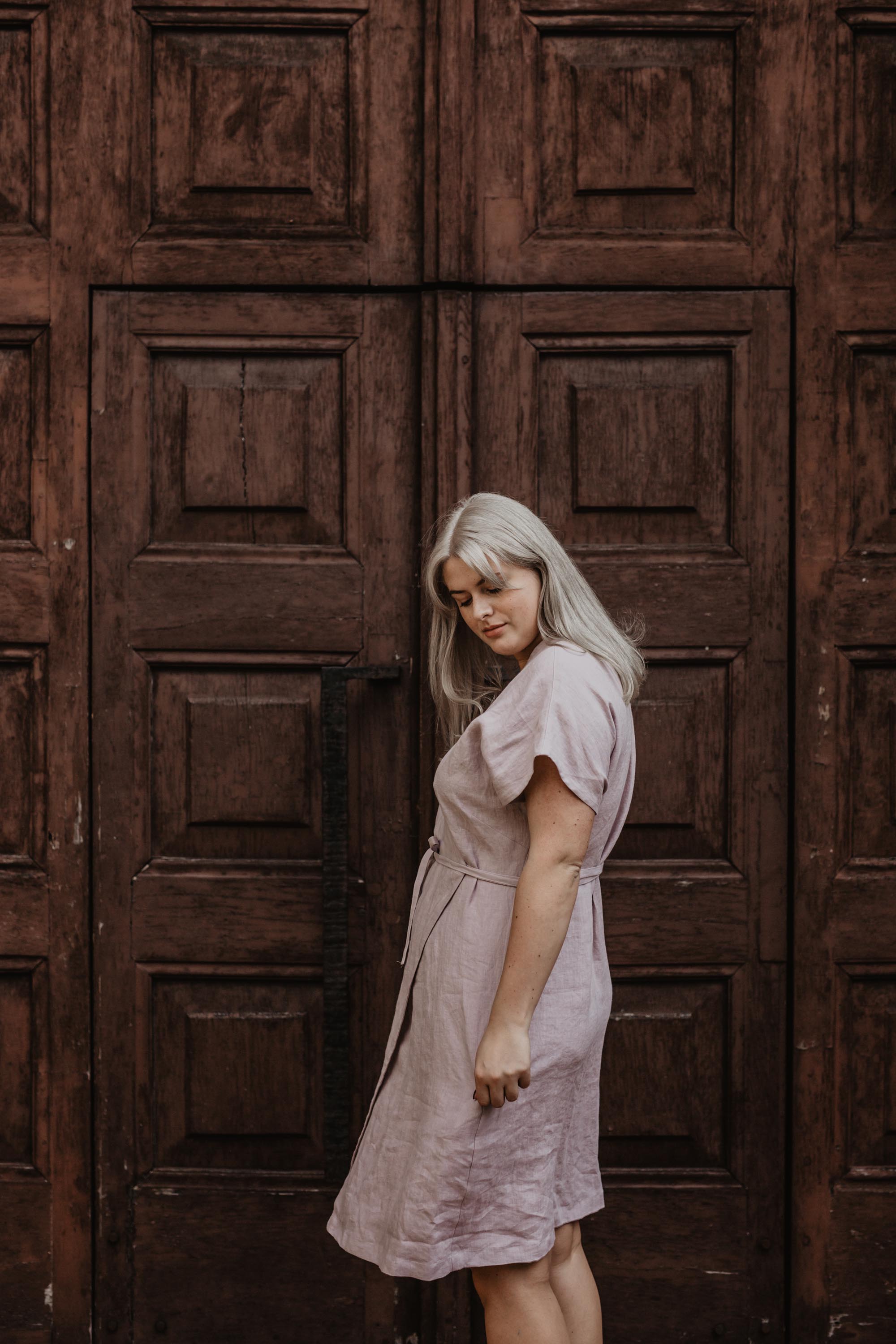 Woman Looking to the side wearing a Dusty Rose Linen Wrap Dress by Amourlinen
